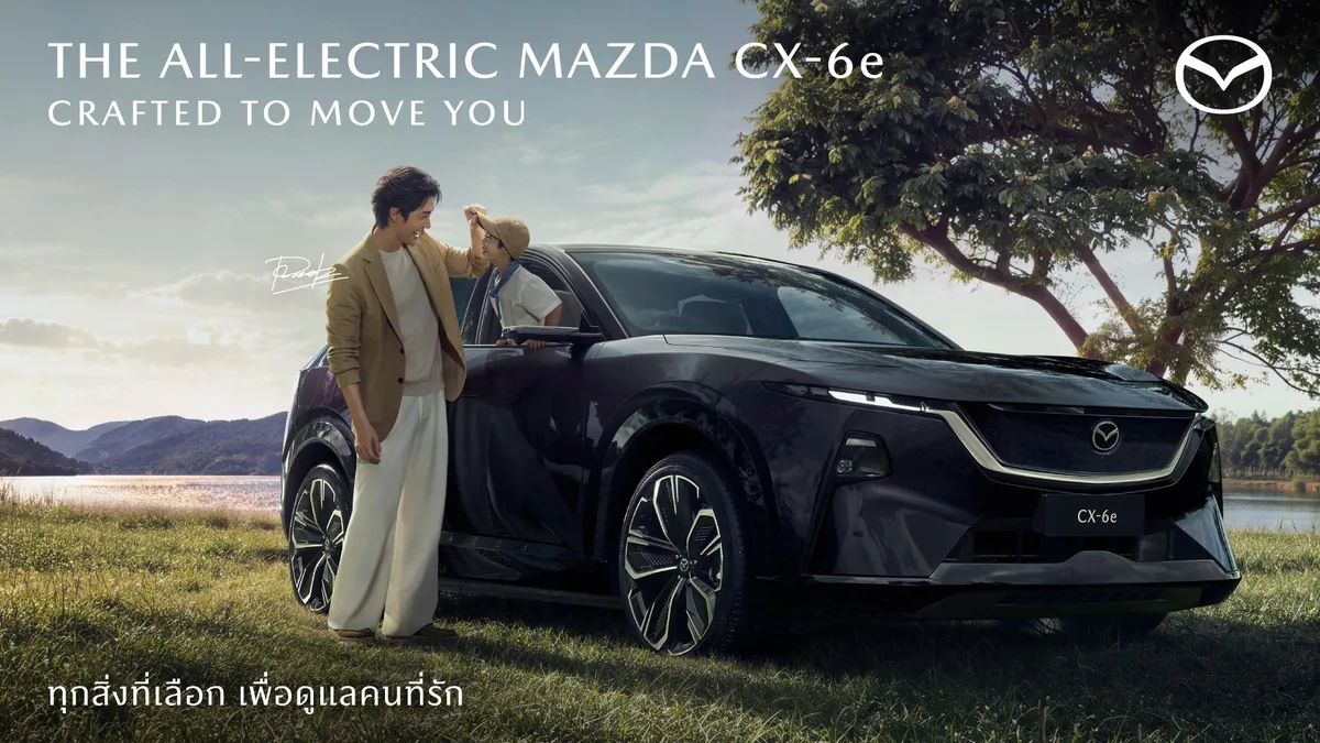 Mazda CX-6e FRIEND OF MAZDA — Art of Caring ดีเจพุฒิ พุฒิชัย และน้องพีเจร่วมแคมเปญ FRIEND OF MAZDA ข้างรถยนต์ไฟฟ้า Mazda CX-6e มุมด้านหน้าสามส่วนสี่ในบรรยากาศกลางแจ้ง