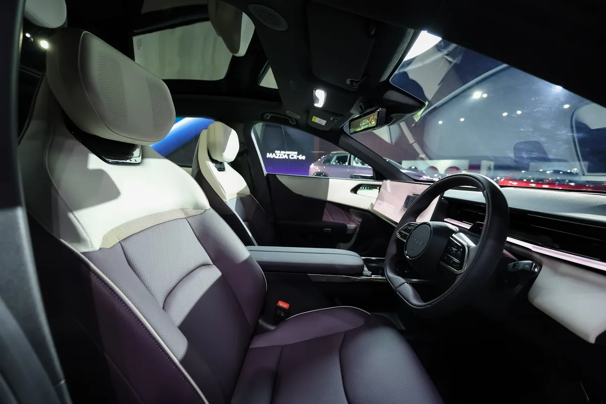 ภายใน Mazda CX-6e รุ่น Premium Sports ห้องโดยสาร Mazda CX-6e พร้อมเบาะคู่หน้าสีม่วง–ขาว คอนโซลกลางและพวงมาลัยขวา
