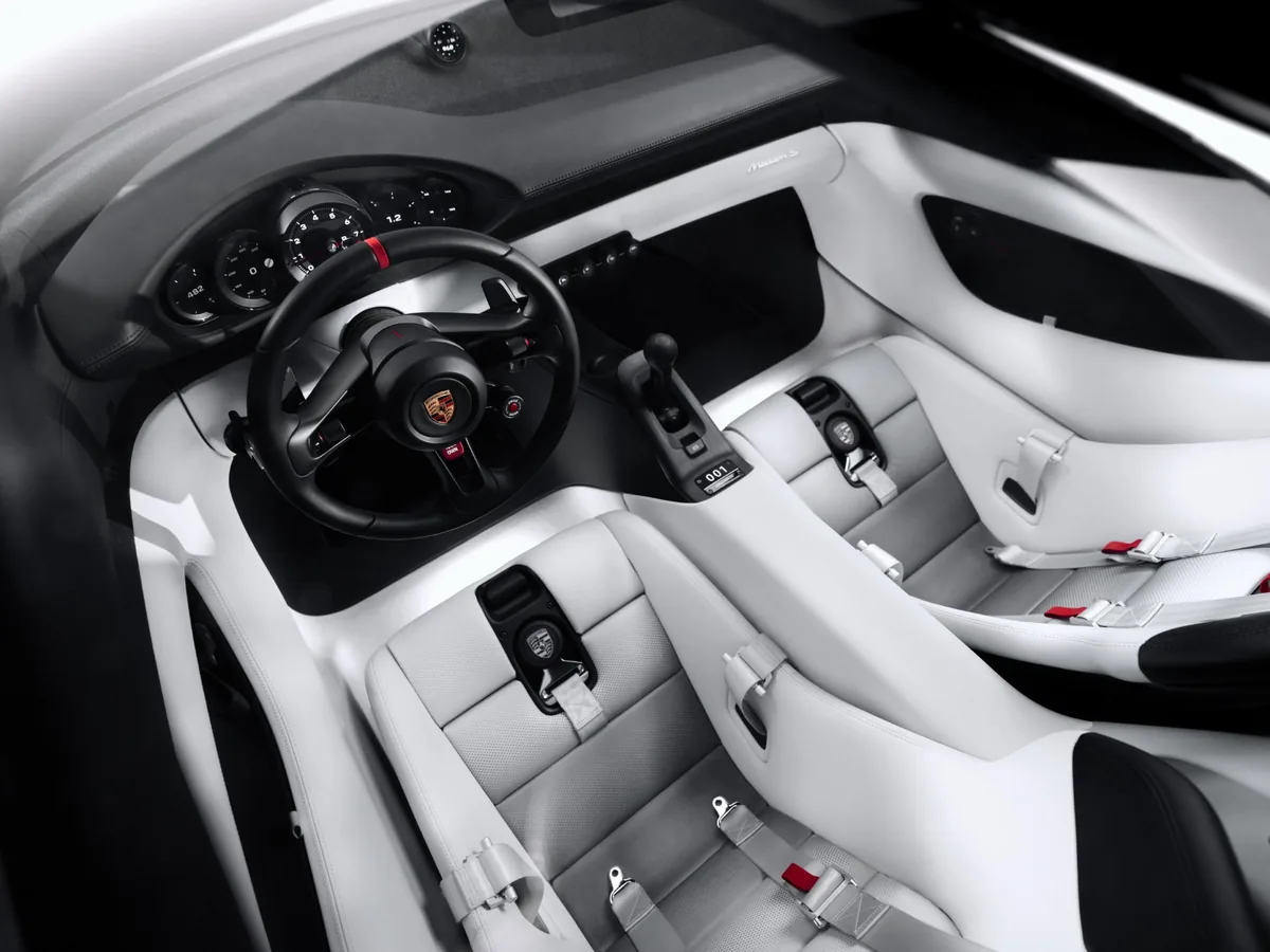 ห้องโดยสารและเบาะ Porsche Mission S ห้องโดยสาร Porsche Mission S มุมสูง เห็นเบาะสปอร์ตสีขาวสองที่นั่ง พวงมาลัย มาตรวัด และคอนโซลกลาง