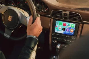 Apple CarPlay บนหน้าจอ PCCM Plus ที่ติดตั้งในคอนโซล Porsche พร้อมพวงมาลัยและผู้ขับขี่