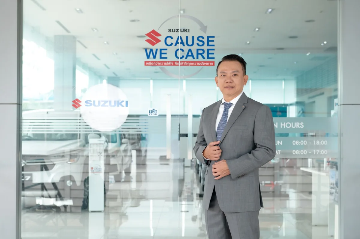 ผู้บริหาร Suzuki กับ Suzuki Cause We Care นายวัลลภ ตรีฤกษ์งาม รองประธานกรรมการบริหาร บริษัท ซูซูกิ มอเตอร์ (ประเทศไทย) จำกัด บริเวณป้าย Suzuki Cause We Care