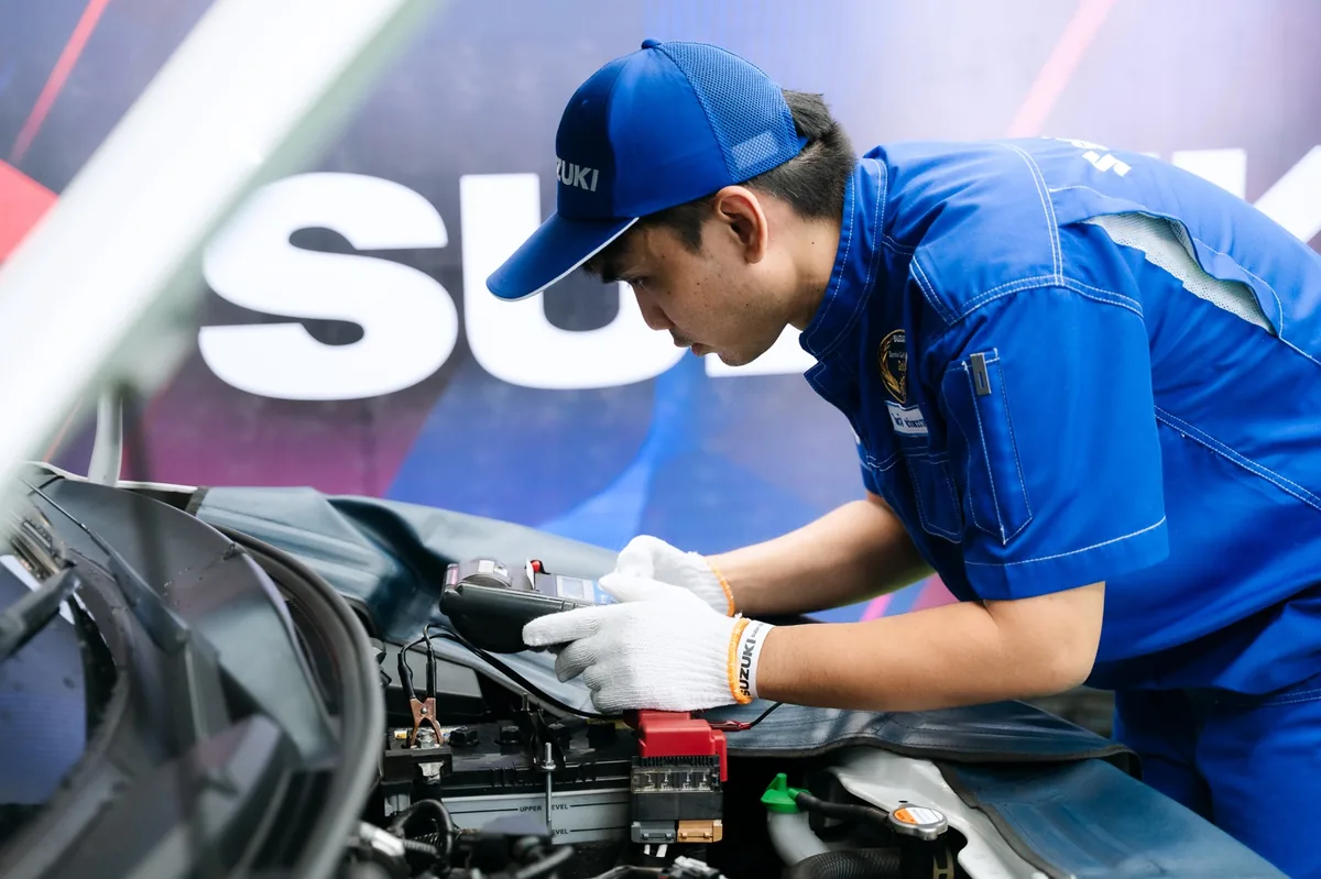 ช่าง Suzuki ตรวจสอบแบตเตอรี่รถยนต์ ช่าง Suzuki ใช้อุปกรณ์ตรวจวัดระบบไฟฟ้าบริเวณแบตเตอรี่รถยนต์