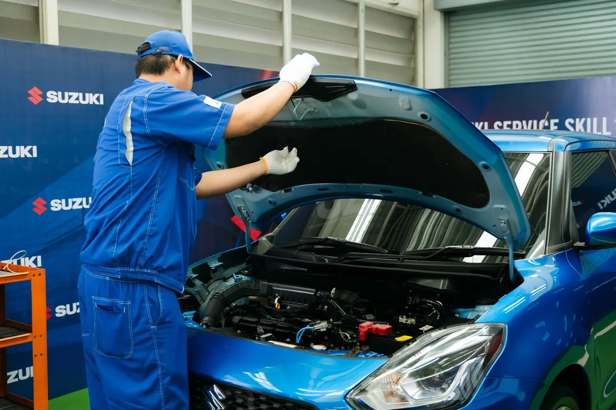 ช่าง Suzuki ตรวจสอบห้องเครื่อง ช่าง Suzuki ตรวจสอบรถบริเวณห้องเครื่องภายในพื้นที่บริการ