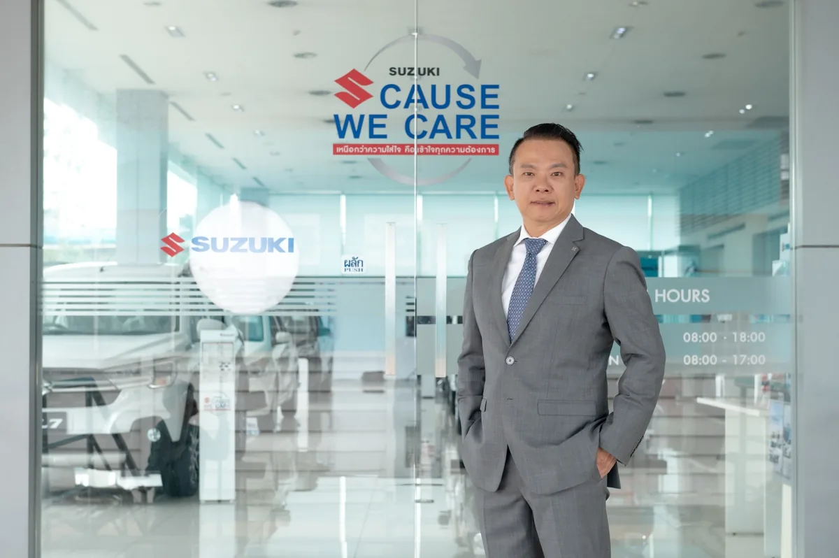 นายวัลลภ ตรีฤกษ์งาม กับโครงการ Suzuki Cause We Care นายวัลลภ ตรีฤกษ์งาม ผู้บริหารซูซูกิ ยืนหน้าทางเข้าศูนย์บริการที่มีสัญลักษณ์ Suzuki Cause We Care