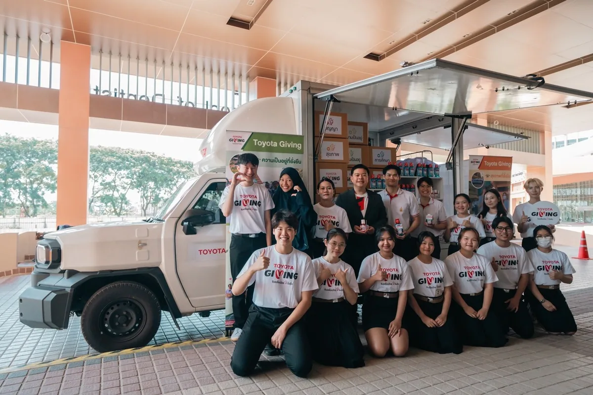 ภาพหมู่ผู้ร่วมกิจกรรมหน้าอุปกรณ์ Toyota Giving กลุ่มผู้ร่วมกิจกรรม TOYOTA GIVING ถ่ายภาพร่วมกันด้านหน้ารถที่จัดแสดงอุปกรณ์ดูแลสุขภาพช่องปาก